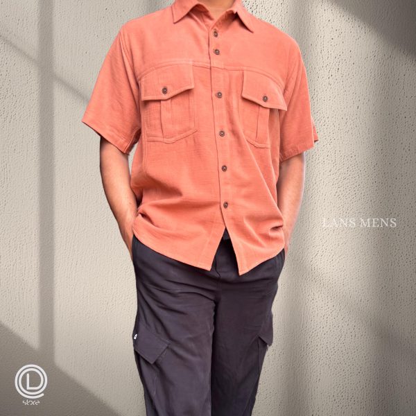 Man wearing a coral short-sleeve cargo shirt with black cargo pants