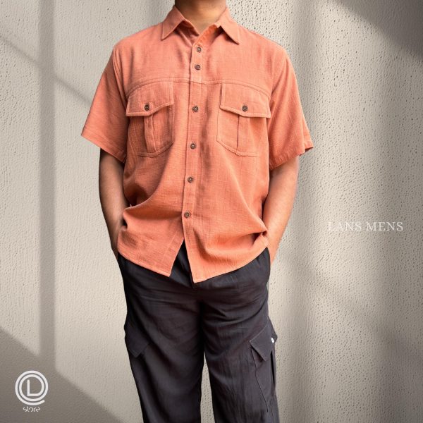 Man wearing a coral short-sleeve cargo shirt with black cargo pants