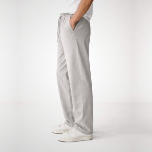 Man wearing loose fit ash grey pants moving effortlessly showing fluid drape