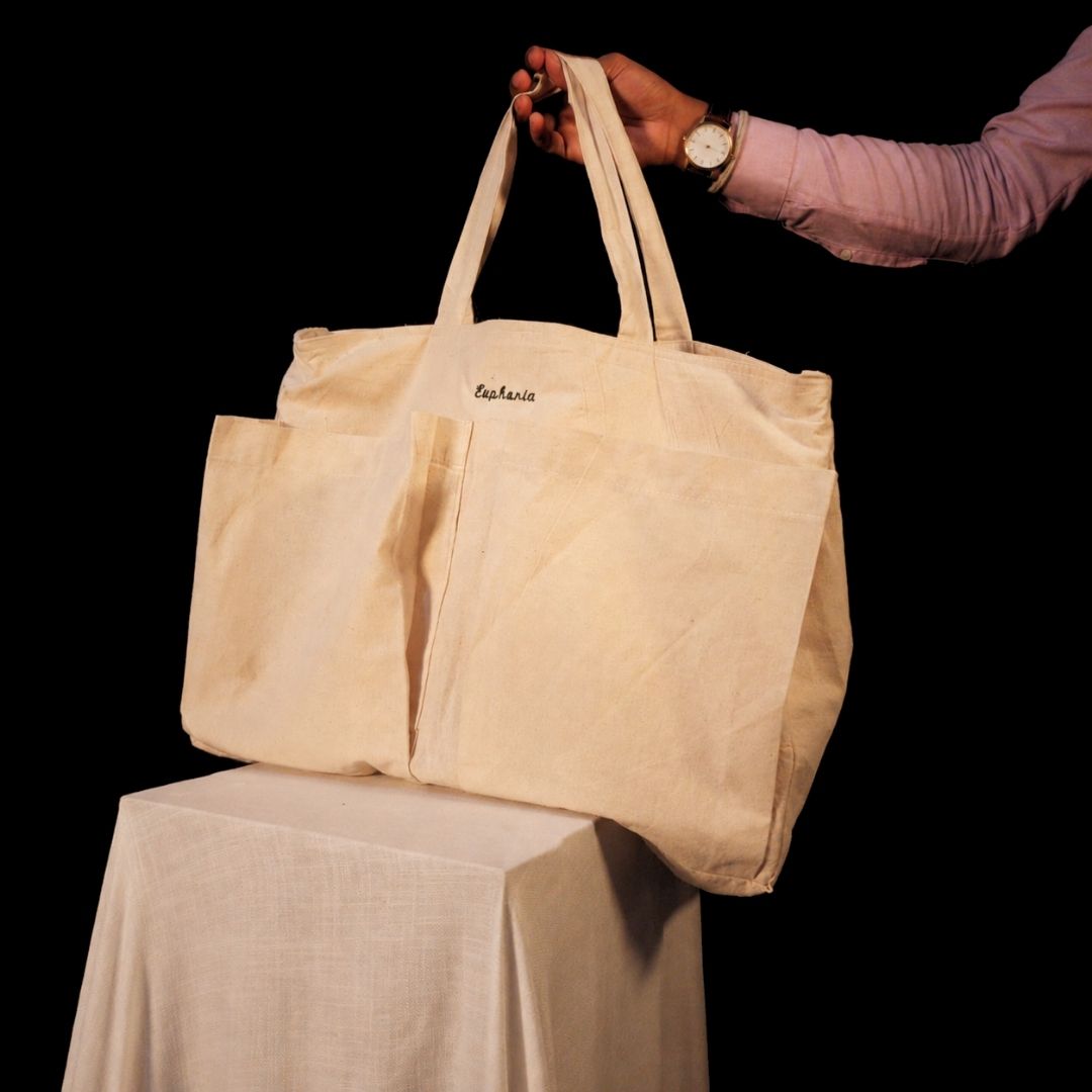 Lans Nomad Tote – Eutopia Embroidery Lans Nomad Tote in natural cotton canvas with Eutopia embroidery and large front pockets