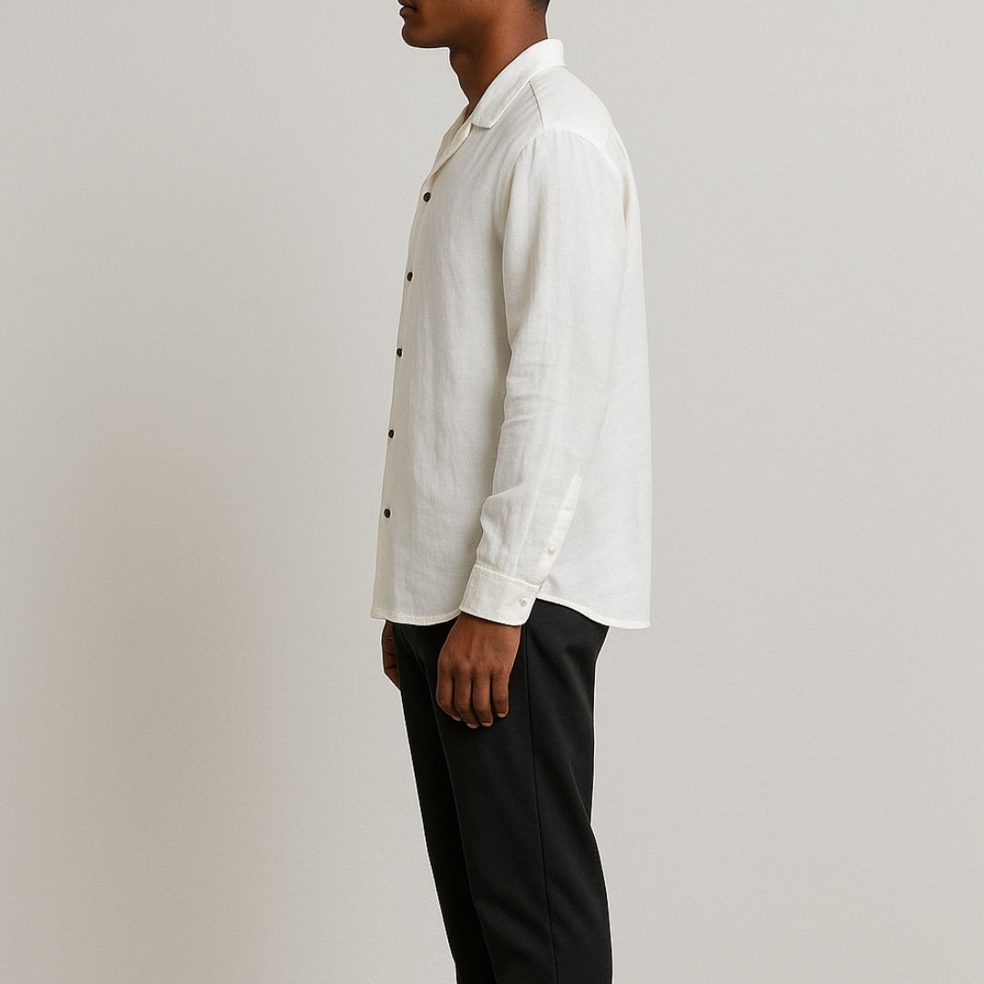 Relaxed Linen Shirt Collection – Black, Harvest Gold & Ivory | Lans Stack of three linen shirts in black, harvest gold, and ivory placed on a wooden stool — part of Lans’ Relaxed Cuban Collar Linen Collection.