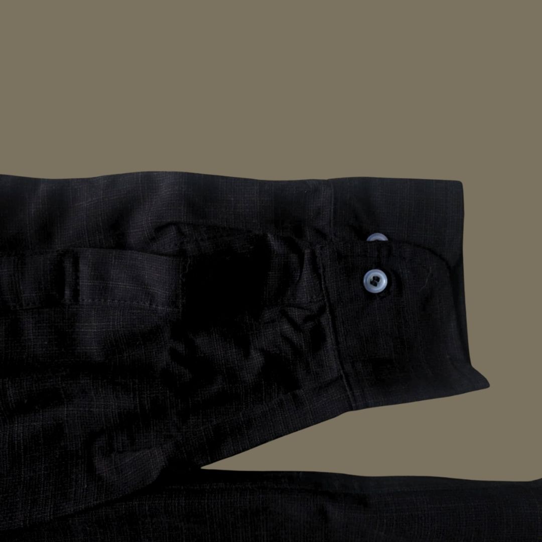 Relaxed Linen Shirt Collection – Black, Harvest Gold & Ivory | Lans Stack of three linen shirts in black, harvest gold, and ivory placed on a wooden stool — part of Lans’ Relaxed Cuban Collar Linen Collection