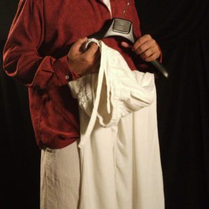 Generic male model wearing an oversized maroon corduroy retro long sleeve shirt with an off-white linen collar and oversized off-white linen drawstring pants on a plain studio background.
